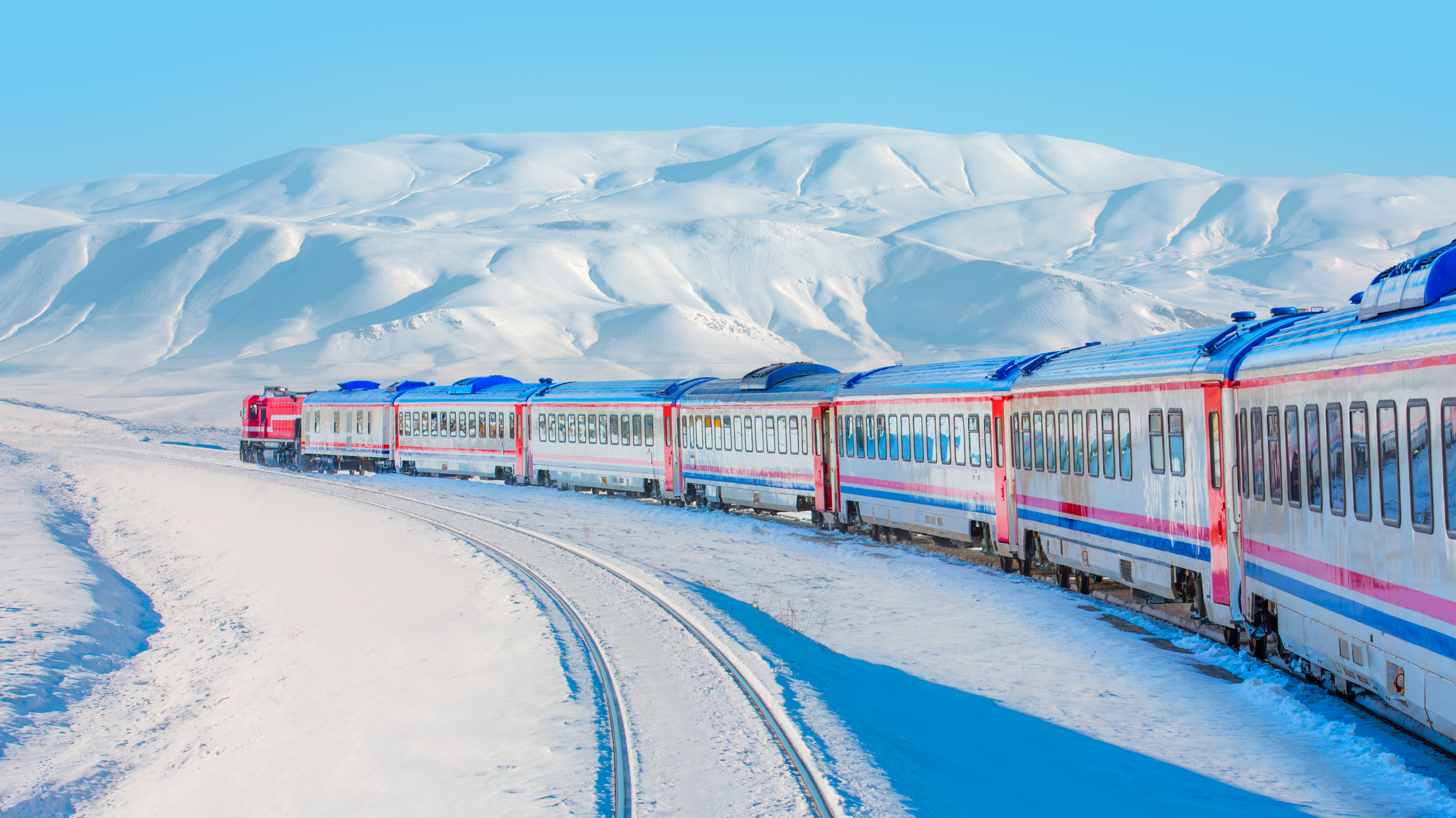 Red diesel train (East express) in motion at the snow covered railway platform - The train connecting Ankara to Kars - Turkey